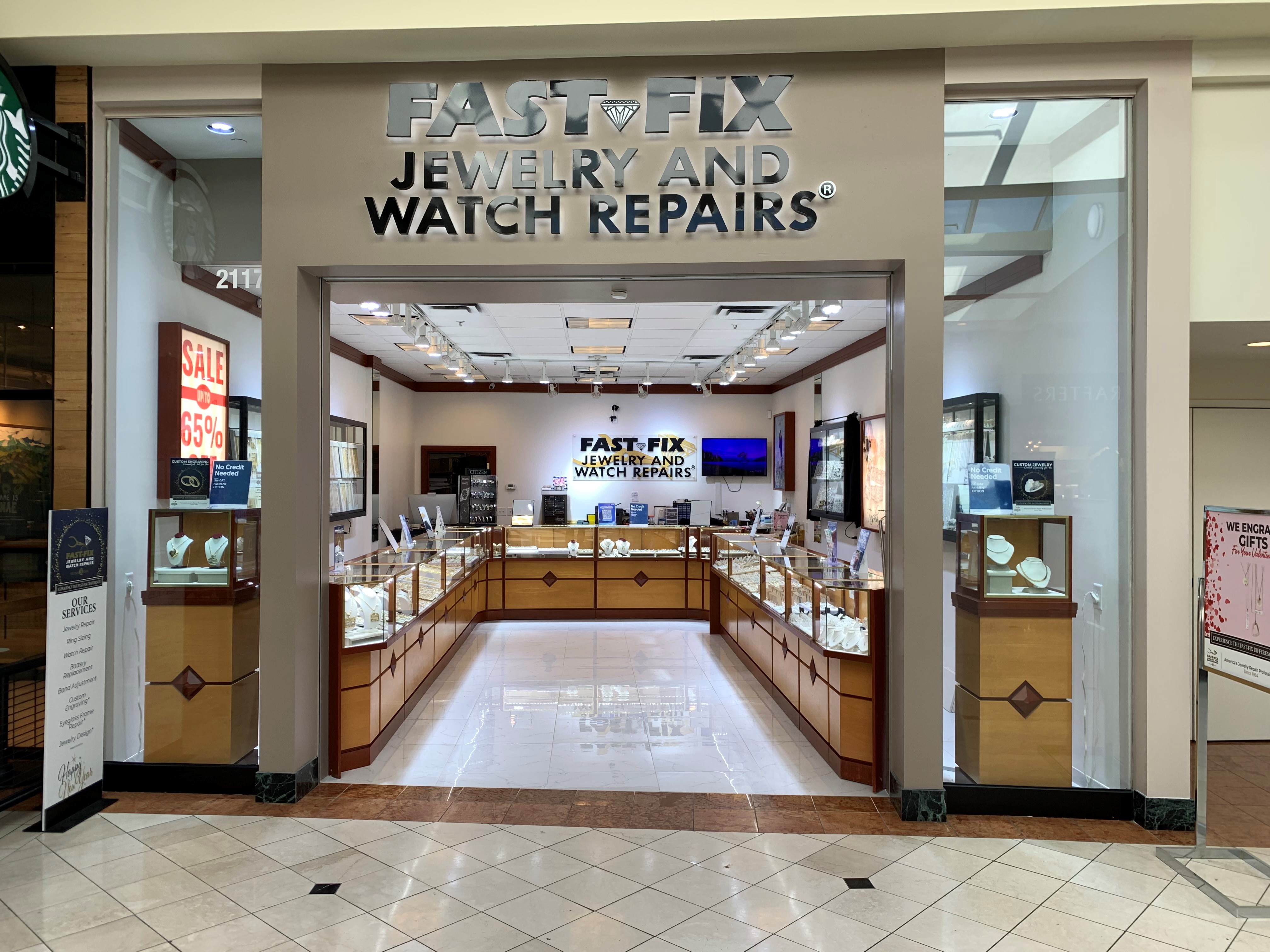 Storefront of Fast-Fix Jewelry and Watch Repairs store at Crabtree Valley Mall. Showcases are positioned in a U-form and lots of gold and diamond jewelry is displayed.