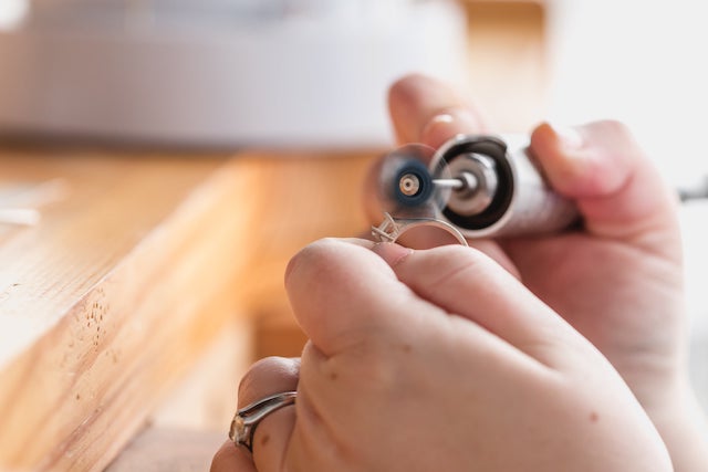 A professional repairs a ring in a store.