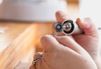 A professional repairs a ring in a store.